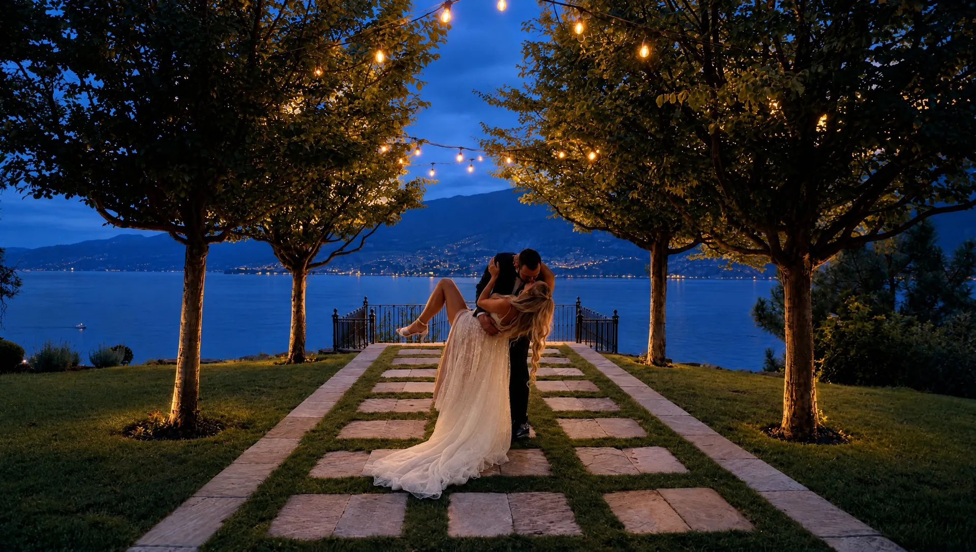 Groom lifting his bride on a lakeside lawn under string lights at Chateau Okanagan, still from a Pixel Pro wedding film