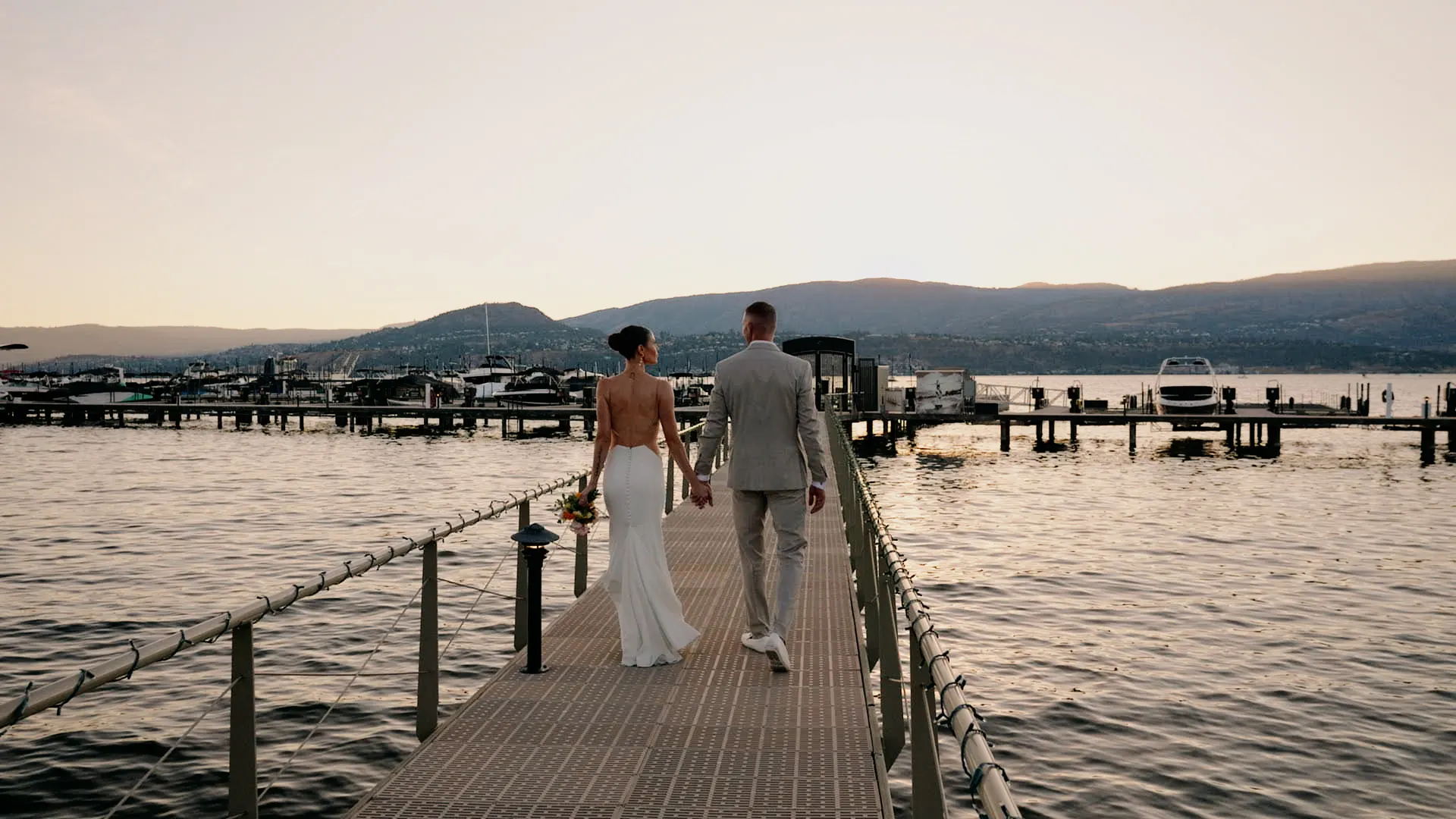 Bride and groom walking down the dock at Manteo Resort, Kelowna