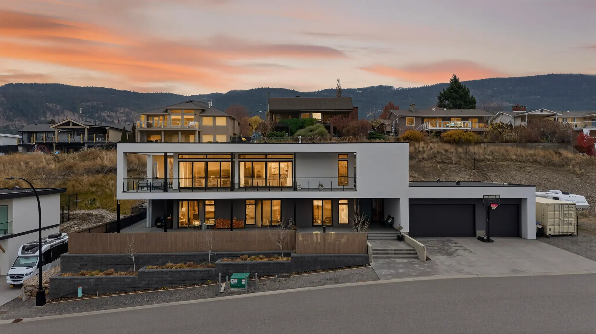 Aerial view twilight, modern lake-view home in Lake Country, BC. Real estate photography by Pixel Pro Productions.