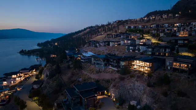 Aerial view twilight, lake-view modern home in Lakestone, Lake Country, BC. Real estate photography by Pixel Pro Productions.